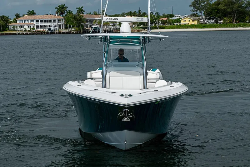 Slide: The Image of 2020 Bahama 41 boat cruising on water, featuring Garmin equipment, with waterfront homes in background. - 2