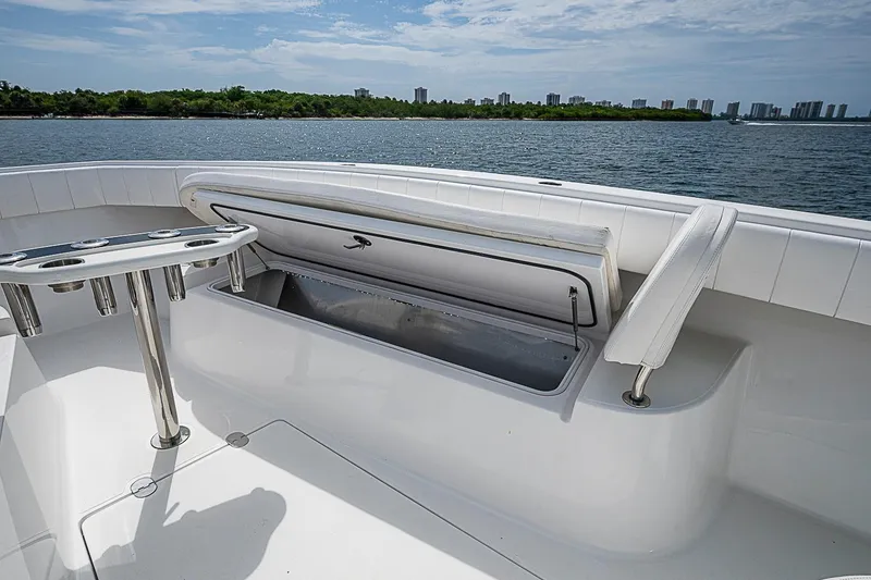 Slide: The Image of 2020 Bahama 41 boat with open storage compartment and rod holders, overlooking scenic waterfront. - 21