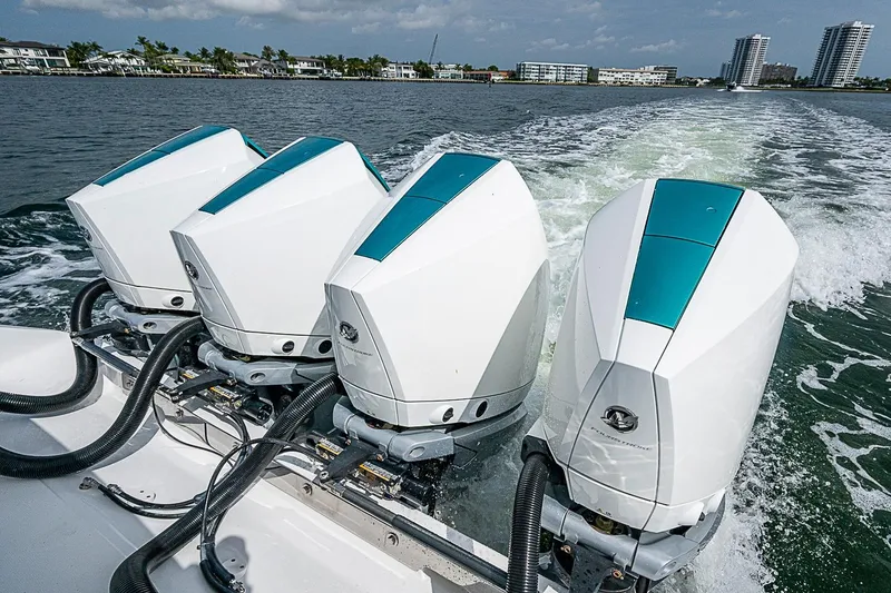 Slide: The Image of Four powerful outboard motors on a 2020 Bahama 41 boat cruising through water. - 24