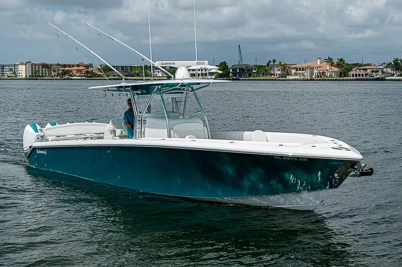 Slide: The Image of 2020 Bahama 41 boat cruising on water with coastal buildings in the background. - 27