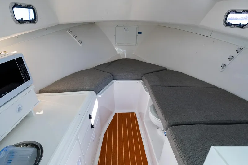 Slide: The Image of 2024 Steiger Craft 31 Fisherman cabin interior with seating, microwave, and wood flooring. - 42