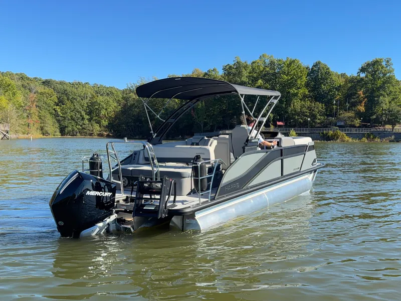 Slide: The Image of A Harris Grand Mariner 230 pontoon boat on a calm lake with trees in the background. - 4