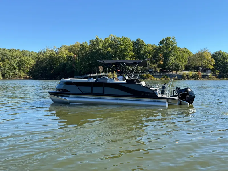 Slide: The Image of A sleek pontoon boat on a calm lake, surrounded by trees. - 7