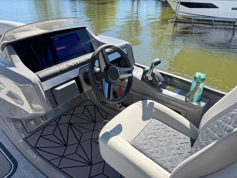 Slide: The Image of The image shows the cockpit of a 2027 Harris Grand Mariner 230 with modern steering wheel and controls. - 15
