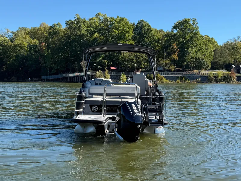 Slide: The Image of A Harris Grand Mariner 230 pontoon boat on a calm lake, surrounded by trees. - 3