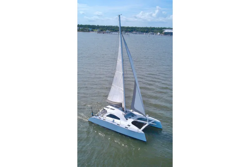 The Image of 2023 Schionning Arrow 1280S catamaran sailing on calm waters. - 0