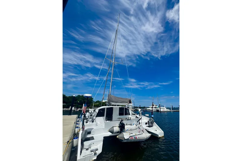 Slide: The Image of 2023 Schionning Arrow 1280S catamaran docked under a vibrant blue sky. - 10
