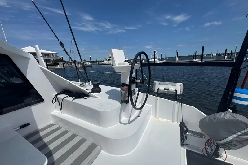 Slide: The Image of 2023 Schionning Arrow 1280S yacht cockpit with steering wheel, docked at marina. - 11