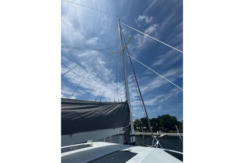 Slide: The Image of Sailing yacht Schionning Arrow 1280S, 2023 model, with mast and rigging against a blue sky. - 12