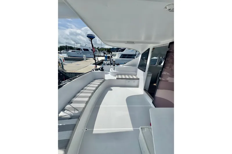 Slide: The Image of 2023 Schionning Arrow 1280S yacht deck with seating, docked at marina. - 14