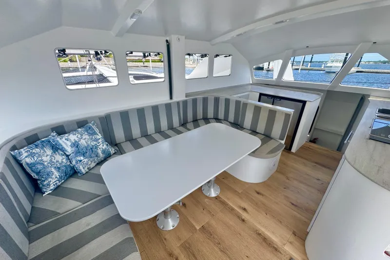 Slide: The Image of Modern interior of 2023 Schionning Arrow 1280S catamaran with striped seating and ocean view. - 15