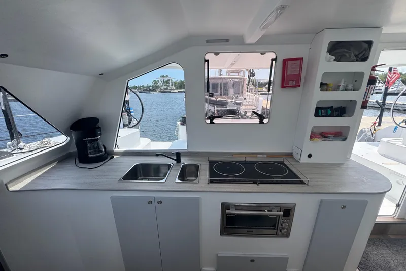 Slide: The Image of Modern kitchen interior of 2023 Schionning Arrow 1280S catamaran with stove, sink, and storage. - 16