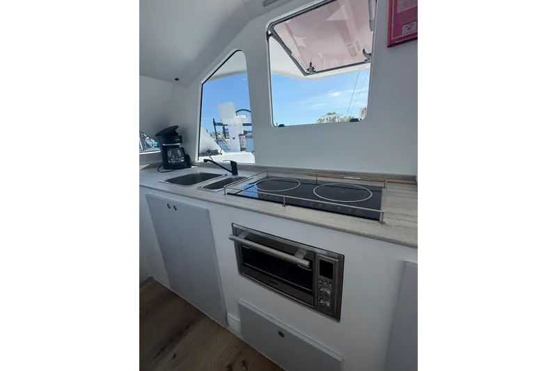 Slide: The Image of Modern kitchen in 2023 Schionning Arrow 1280S yacht with stove, sink, and window view. - 17