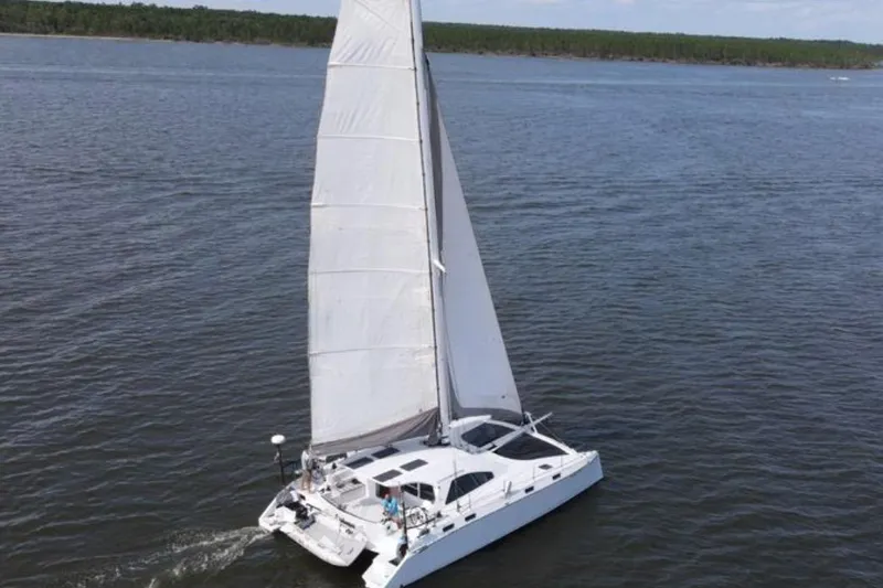 Slide: The Image of 2023 Schionning Arrow 1280S catamaran sailing on open water. - 2