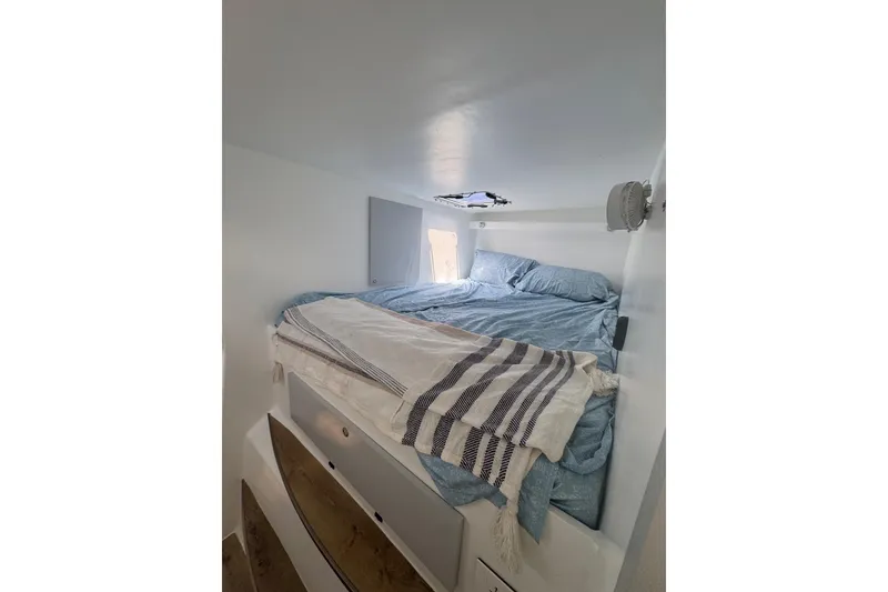 Slide: The Image of Cozy cabin bedroom in 2023 Schionning Arrow 1280S catamaran with blue bedding and striped blanket. - 21