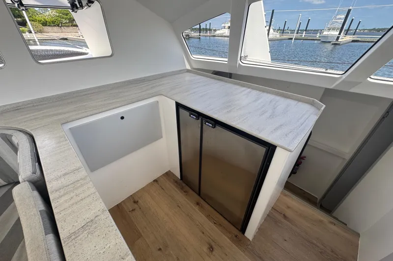Slide: The Image of Modern interior of 2023 Schionning Arrow 1280S yacht with sleek countertops and scenic marina view. - 27