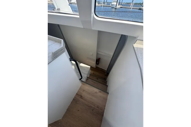 Slide: The Image of Staircase inside 2023 Schionning Arrow 1280S yacht, leading to lower deck with wooden steps. - 28