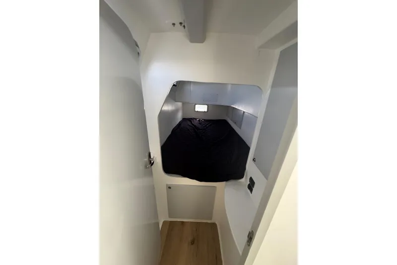 Slide: The Image of Interior cabin of 2023 Schionning Arrow 1280S catamaran, featuring a cozy sleeping area. - 29