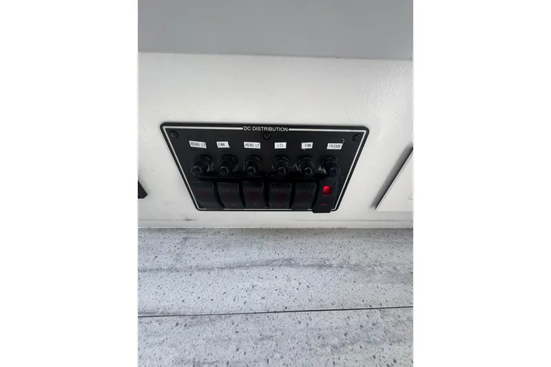 Slide: The Image of DC distribution panel on 2023 Schionning Arrow 1280S catamaran, featuring labeled switches. - 31