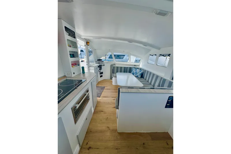 Slide: The Image of Modern interior of 2023 Schionning Arrow 1280S catamaran with kitchen and seating area. - 35
