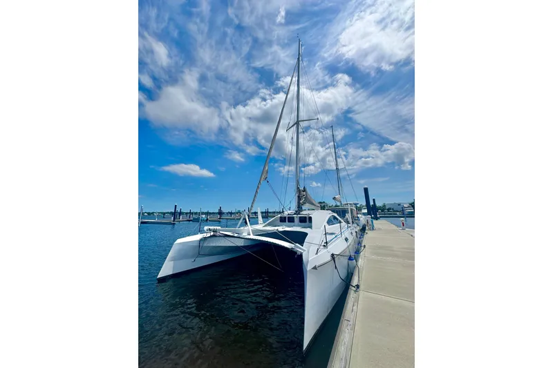 Slide: The Image of 2023 Schionning Arrow 1280S catamaran docked under a bright blue sky. - 5