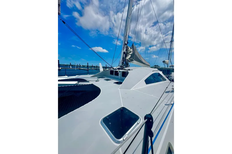 Slide: The Image of 2023 Schionning Arrow 1280S catamaran docked under a bright blue sky. - 7