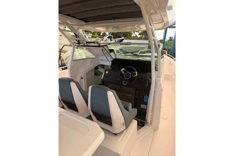 Slide: The Image of 2024 Axopar 37 Sun-Top boat interior with dual seats and steering console. - 11