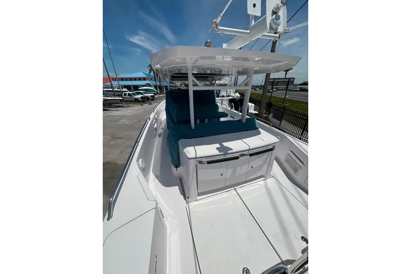 Slide: The Image of 2024 Axopar 37 Sun-Top boat with sleek design and spacious deck under clear skies. - 2