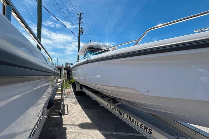 Slide: The Image of 2024 Axopar 37 Sun-Top boat on trailer under clear blue sky. - 5