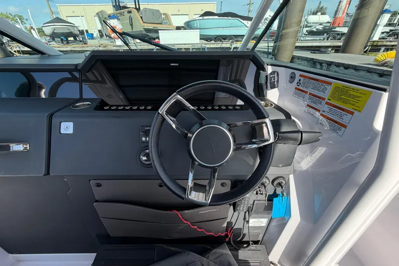 Slide: The Image of 2024 Axopar 37 Sun-Top boat dashboard with steering wheel and control panel. - 7