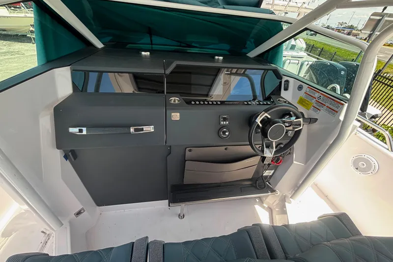 Slide: The Image of 2024 Axopar 37 Sun-Top helm with modern steering wheel and control panel. - 9