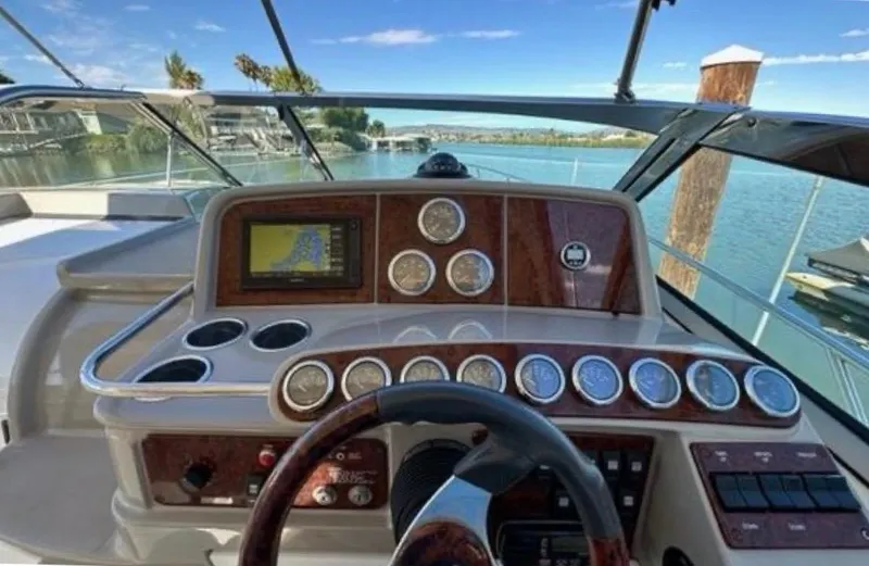 Slide: The Image of 2003 Formula 37 PC yacht dashboard with gauges and navigation system, overlooking serene waters. - 14