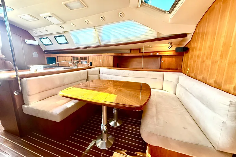 Slide: The Image of Luxurious interior of 2007 Hunter 41 Deck Salon with plush seating and wooden table. - 13
