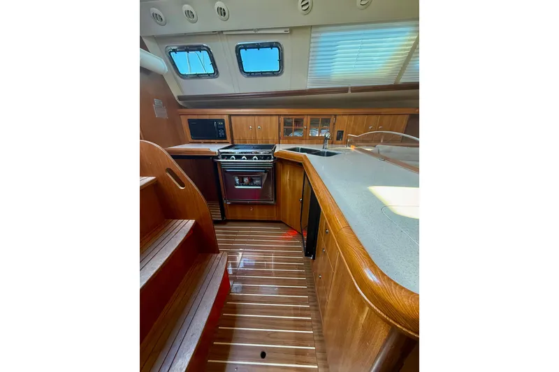 Slide: The Image of Luxurious 2007 Hunter 41 Deck Salon interior with wood finish and modern kitchen amenities. - 15