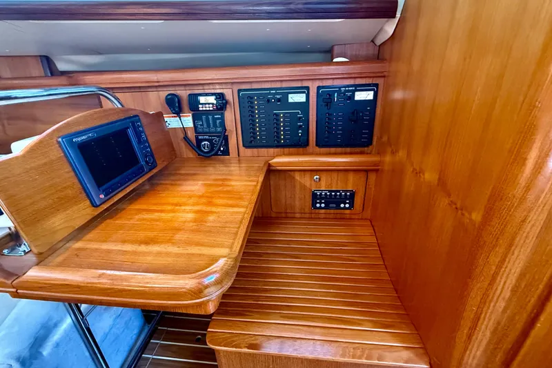 Slide: The Image of 2007 Hunter 41 Deck Salon navigation station with control panels and wood finish. - 16