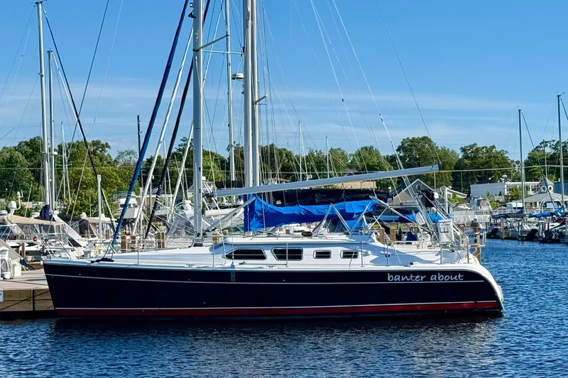Slide: The Image of 2007 Hunter 41 Deck Salon sailboat docked at a marina under clear blue skies. - 2