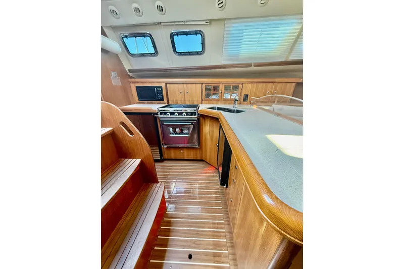 Slide: The Image of 2007 Hunter 41 Deck Salon interior with wooden cabinetry and modern kitchen appliances. - 21