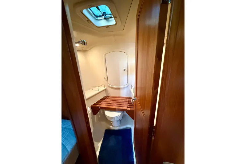 Slide: The Image of Bathroom interior of 2007 Hunter 41 Deck Salon yacht, featuring wooden accents and skylight. - 29