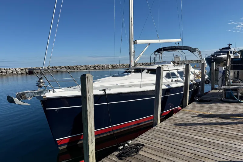 Slide: The Image of 2007 Hunter 41 Deck Salon sailboat docked at a marina under clear blue skies. - 3
