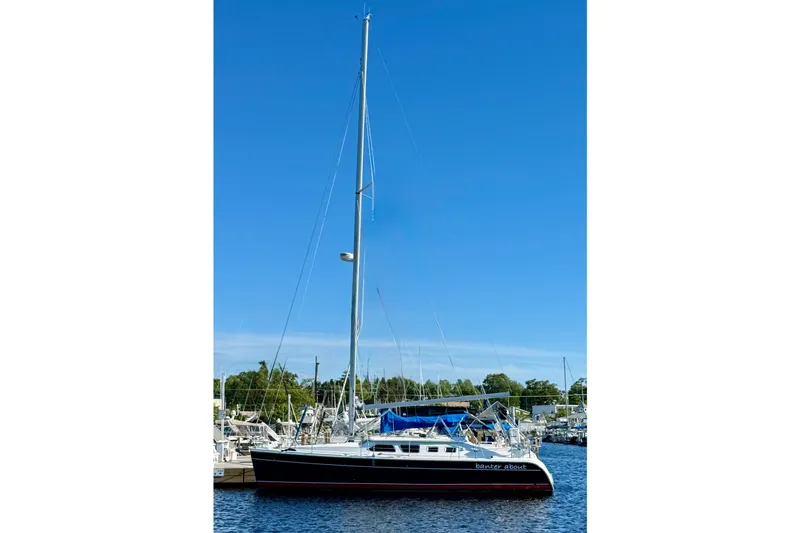 Slide: The Image of 2007 Hunter 41 Deck Salon sailboat docked at marina under clear blue sky. - 6