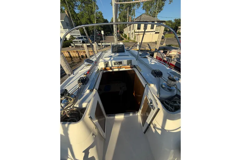 Slide: The Image of 2007 Hunter 41 Deck Salon sailboat cockpit with open cabin doors, docked in a marina. - 9