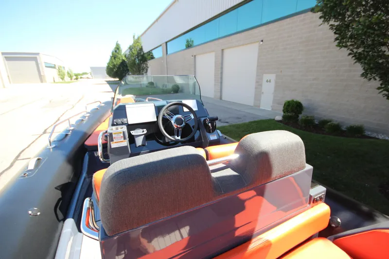 Slide: The Image of 2021 Zodiac Medline 7.5 boat interior with steering wheel and dashboard, parked near a building. - 14