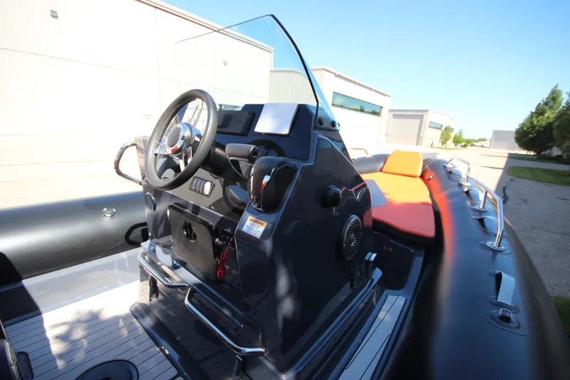 Slide: The Image of 2021 Zodiac Medline 7.5 boat interior with steering console and orange seating. - 18
