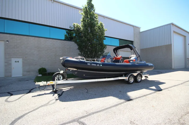 Slide: The Image of 2021 Zodiac Medline 7.5 boat on trailer, parked outside industrial building. - 2