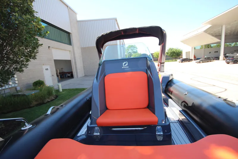 Slide: The Image of 2021 Zodiac Medline 7.5 boat with orange seating, parked outdoors near buildings. - 20