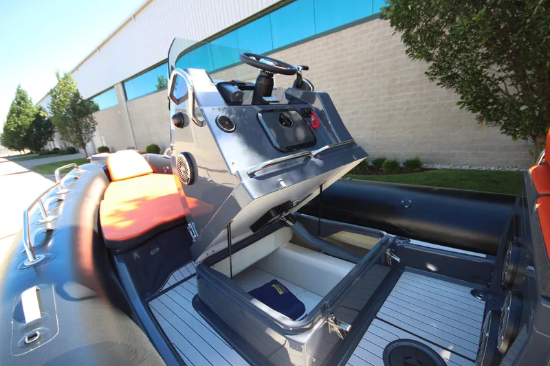 Slide: The Image of 2021 Zodiac Medline 7.5 boat with open storage compartment, docked outdoors. - 21