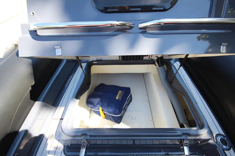 Slide: The Image of Open storage compartment of 2021 Zodiac Medline 7.5 boat with blue bag inside. - 22