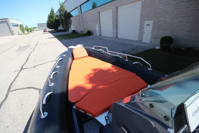 Slide: The Image of 2021 Zodiac Medline 7.5 boat with orange seating, parked near industrial buildings. - 24