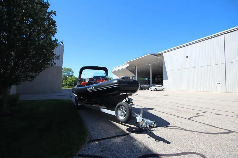 Slide: The Image of 2021 Zodiac Medline 7.5 boat on trailer outside large building under clear blue sky. - 3