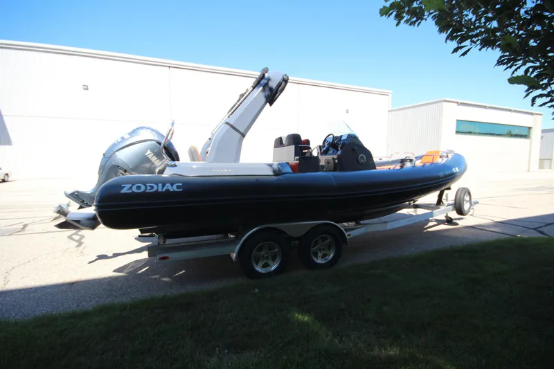 Slide: The Image of 2021 Zodiac Medline 7.5 boat on trailer, parked outdoors near industrial buildings. - 6